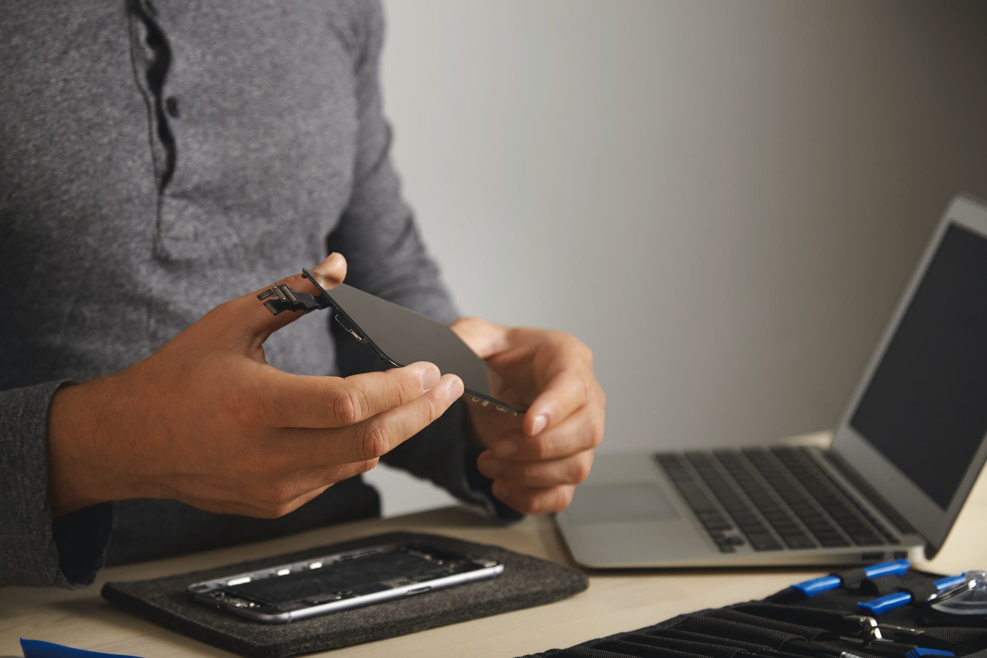computer-and-phone-repairment-service Broken smartphone repair technician working on cellphone screen replacement.